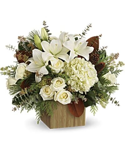 Give the gift of modern winter-white style with this breathtaking bouquet, hand-arranged in a wooden cube.
This winter bouquet includes white hydrangea, white roses, white asiatic lilies, magnolia leaves, seeded eucalyptus, spiral eucalyptus, flat cedar and white pine.